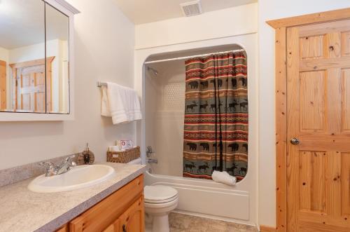 a bathroom with a sink and a toilet and a shower at Henrys Post by KABINO Dog Friendly Foosball Fire Pit SmartTV WiFi in Island Park