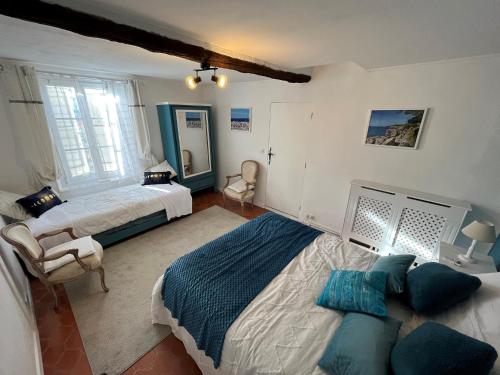 een slaapkamer met 2 bedden en een stoel bij Villa Harmonie - unique provençal charm in Antibes