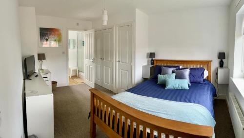 um quarto com uma cama grande e almofadas azuis em Stunning Large Detached Gloucester, 4 beds, 3 bedroom, 2 bathroom property, Nr Chelt, The Docks and Quays sleeps 6 em Gloucester
