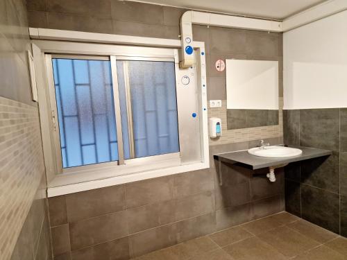 バルセロナにあるArc House Barcelonaのバスルーム(洗面台、窓付)