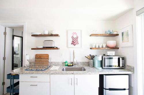 a kitchen with a sink and a microwave at Casa Limonada Boutique Motel in Sarasota