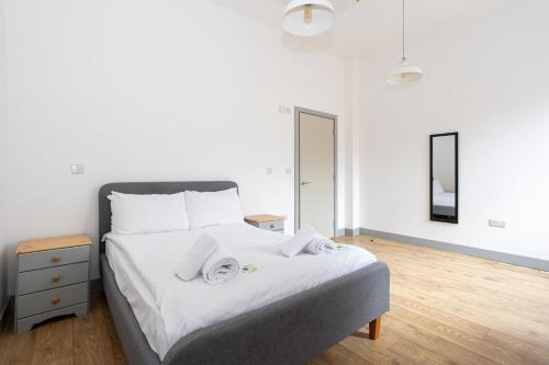 1 dormitorio con 1 cama con toallas en Pillo Rooms Serviced Apartments - Salford, en Mánchester