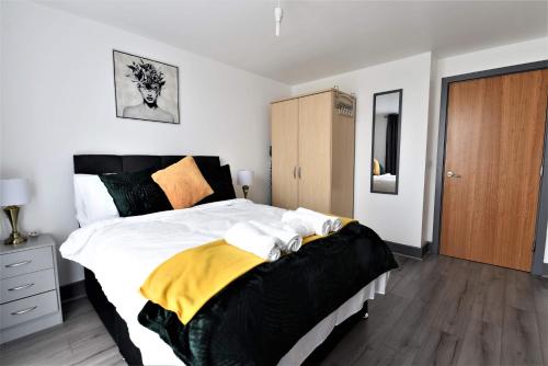 1 dormitorio con 1 cama grande con manta amarilla en Stunning, 1-Bedroom Cosy Apartment in the Centre of Birmingham en Birmingham