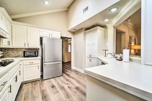 a kitchen with white cabinets and a refrigerator at Lubbock Home with Patio about 6 Mi to Texas Tech! in Lubbock