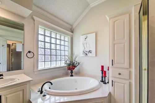a bathroom with a large tub and a window at Lubbock Home with Patio about 6 Mi to Texas Tech! in Lubbock