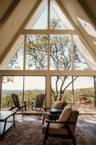 a large window in a room with chairs and a table at NEW - Unique A-frame in Canyon Lake in Spring Branch