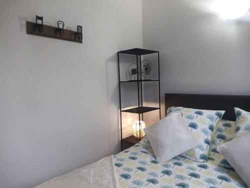 - une chambre avec un lit et une lampe à côté dans l'établissement joli appartement T2 très bien situé, parking couvert, à Lourdes