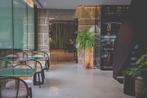 a restaurant with tables and chairs and a plant at Quinta de Silvalde in Santo Tirso