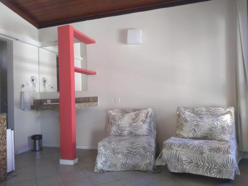 a room with two chairs and a red pole at Hotel Pousada do Sol in Aracaju