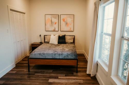 a bedroom with a bed and two windows at NEW - Unique A-frame in Canyon Lake in Spring Branch