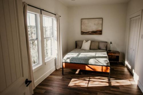 a bedroom with a bed and two windows at NEW - Unique A-frame in Canyon Lake in Spring Branch