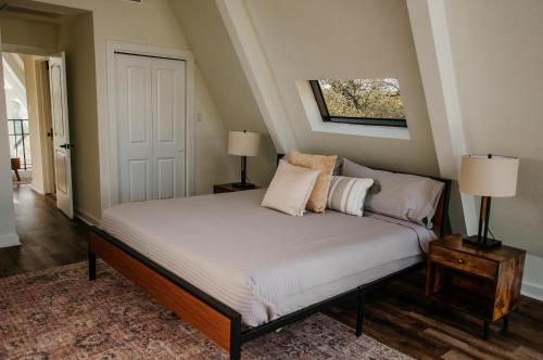 a bed in a room with two lamps and a window at NEW - Unique A-frame in Canyon Lake in Spring Branch