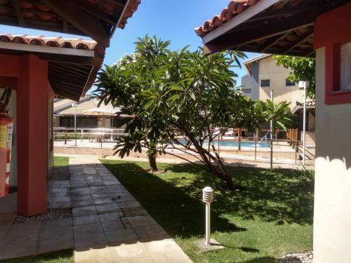 a tree in a yard next to a building at Hotel Pousada do Sol in Aracaju
