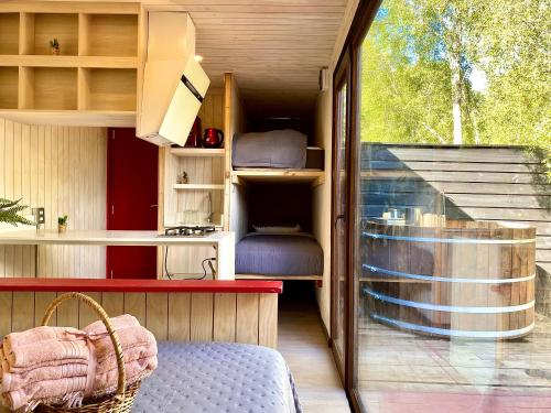 Zimmer mit einem Bett und einer Küche mit einem Fenster in der Unterkunft Refugio 14 con tinaja caliente camino a Futrono in Los Lagos