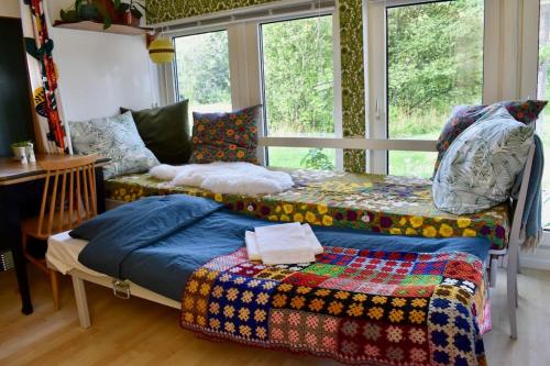 ein Schlafzimmer mit einem Bett, einem Sofa und Fenstern in der Unterkunft Himlakull B&B. Near the forest with swimming pond. in Grimslöv