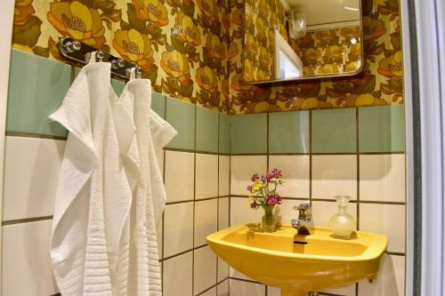 y baño con lavabo amarillo y toallas blancas. en Himlakull B&B. Near the forest with swimming pond., en Grimslöv