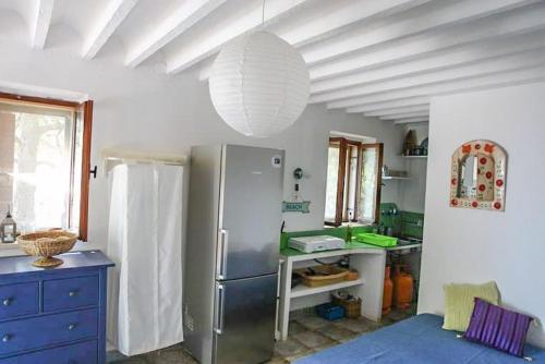 een keuken met een koelkast en een blauwe kast bij A small stone house by the sea, in a wineyard in Nerežišće