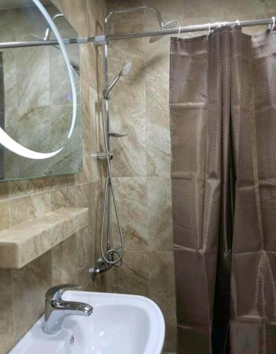 a bathroom with a sink and a glass shower at GUEST HOUSE 15A in Kutaisi