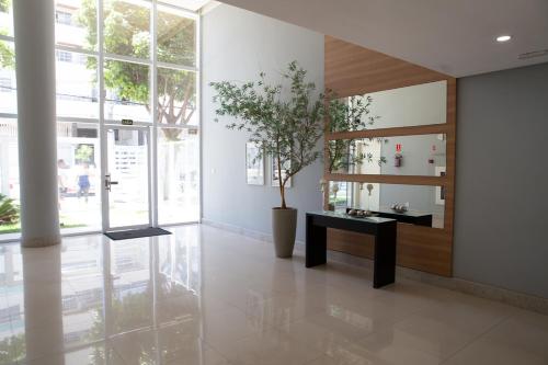um corredor com uma mesa e um vaso de plantas em Apto moderno próximo à Praia de Itaparica ES em Vila Velha
