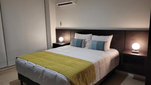 a bedroom with a large bed with two lamps at Dessau VI in San Luis