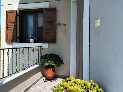 a balcony with two potted plants and a window at ZENIA Pelion garden house in Platanidia