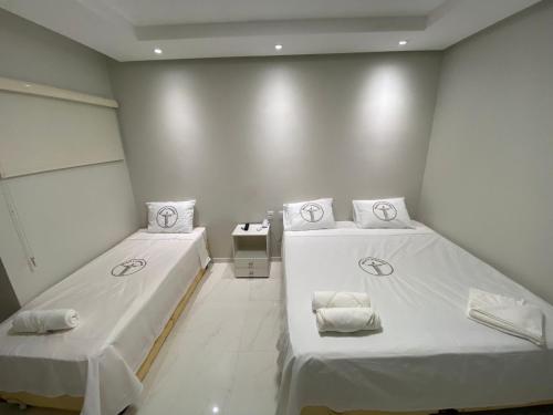 two beds in a room with white walls at Hotel Castanhal in Castanhal