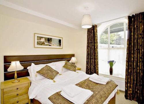 a bedroom with a large bed and a window at Croft Mill in Hebden Bridge