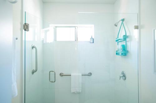 a bathroom with a shower with a glass door at Casa Limonada Boutique Motel in Sarasota