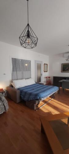 a bedroom with a large bed with a blue blanket at APPARTAMENTO HEIDI IN CENTRO STORICO in Lazise