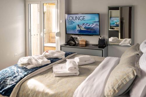 a bedroom with towels on a bed with a television at "Elegance" Central Luxury Apartment Piraeus in Piraeus