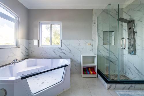 a white bathroom with a sink and a shower at BayWatch Villa - Montego Bay in Montego Bay