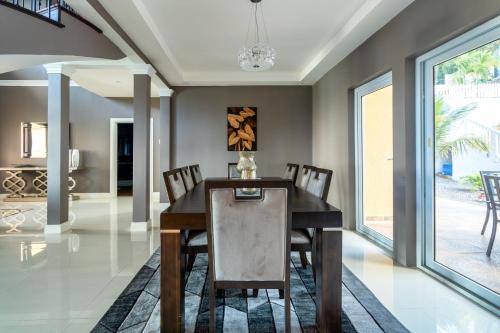 a dining room with a wooden table and chairs at BayWatch Villa - Montego Bay in Montego Bay