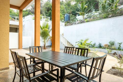 a wooden table and chairs on a patio at BayWatch Villa - Montego Bay in Montego Bay