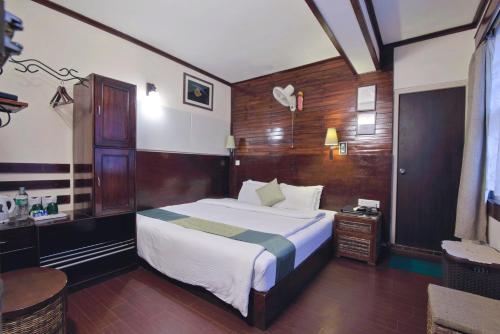 a bedroom with a large bed and a desk at The Nettle and Fern Hotel Gangtok in Gangtok
