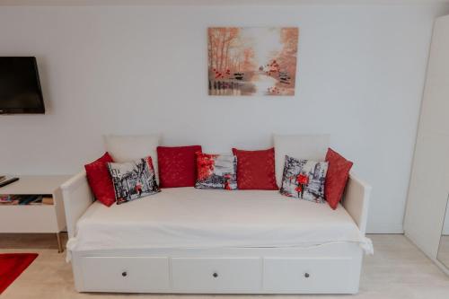 un sofá blanco con almohadas rojas en la sala de estar. en Cannock Chase Guest House Self Catering incl all home amenities & private entrance en Cannock