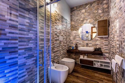 een badkamer met een toilet, een wastafel en een spiegel bij La Dimora del Duca Luxury in Giungano