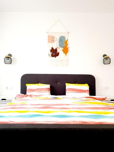 a bedroom with a bed with a colorful striped blanket at Eden Apartment in Cluj-Napoca