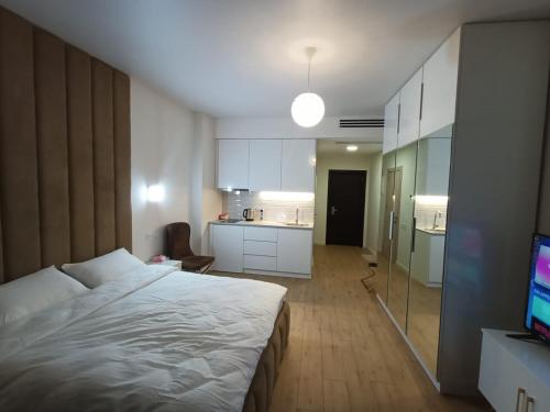 a bedroom with a large bed and a kitchen at Solo Visit Apartments 1709 B in Batumi