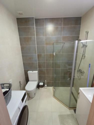 a bathroom with a toilet and a glass shower at Solo Visit Apartments 1709 B in Batumi
