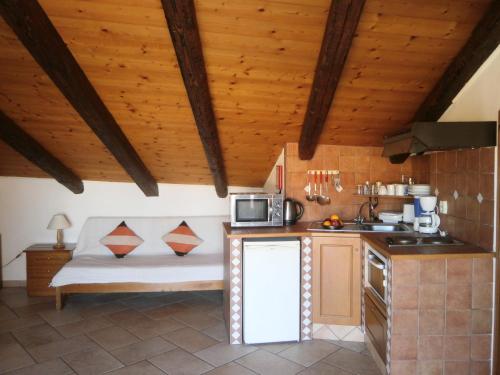 a kitchen with a couch in a room with wooden ceilings at Eva Studios in Kassiopi