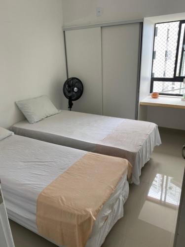 1 dormitorio con 2 camas y ventana en apto na quadra do mar, en Recife