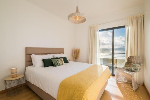 a bedroom with a large bed and a window at Mar Grande Apartment in Ribeira Grande