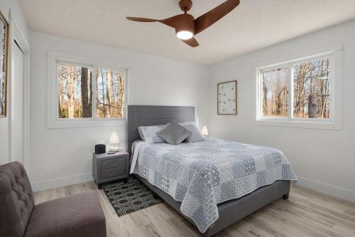 - une chambre avec un lit et un ventilateur de plafond dans l'établissement Lakefront Getaway by Michigan Waterfront Luxury Properties, à Rothbury