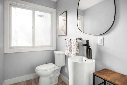 ein Badezimmer mit einem weißen WC und einem Spiegel in der Unterkunft Lakefront Getaway by Michigan Waterfront Luxury Properties in Rothbury