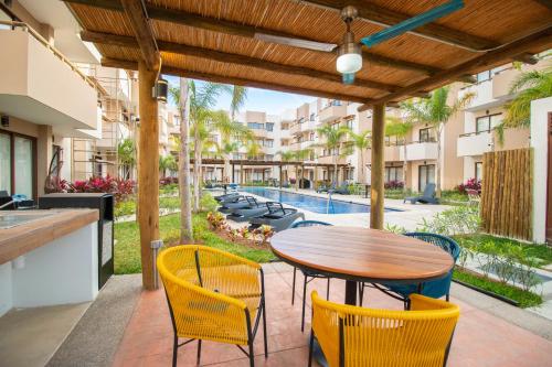 un patio con mesa, sillas y piscina en Ambar Condominios Mazatlan, en Mazatlán