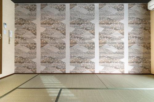 a room with a wall with a patterned wall at Tabist Sparkling Dolphins Inn Kyoto in Kyoto