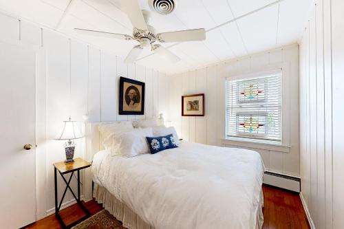 Town of Rehoboth Beach --- 51 Olive Ave في شاطئ ريهوبوث: غرفة نوم بيضاء مع سرير ومروحة سقف