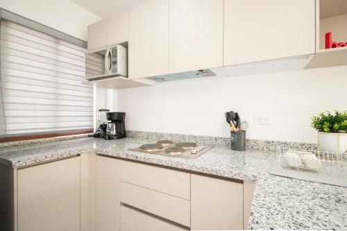 a kitchen with white cabinets and a counter top at Ambar Condominios Mazatlan in Mazatlán