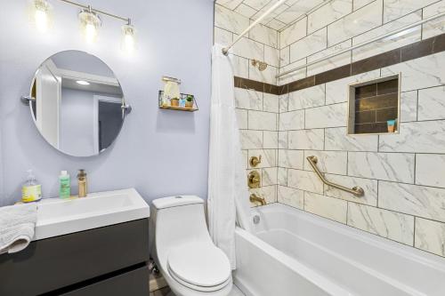 een badkamer met een toilet, een wastafel en een bad bij Sandy Beach Retreat in Oceanside