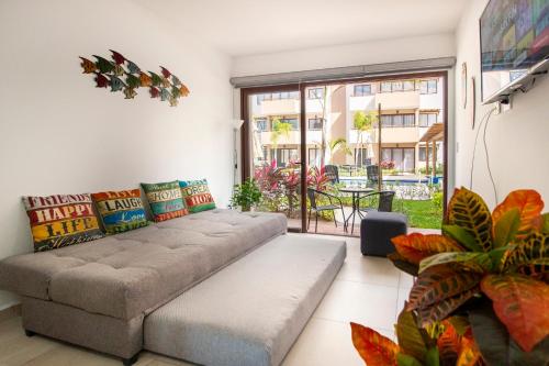 Ambar Condominios Mazatlan في مازاتلان: غرفة معيشة مع أريكة ونافذة كبيرة